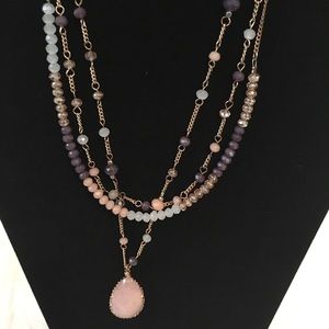 Three layer gold necklace with purple/pink beads.